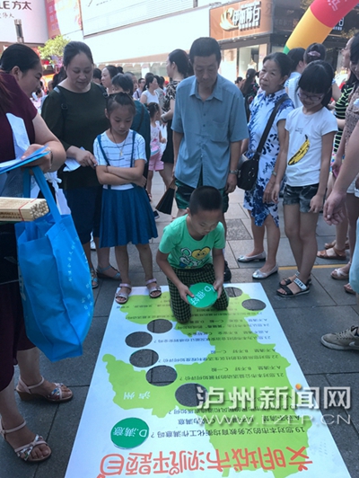 市民在宣傳點(diǎn)參加創(chuàng)文趣味游戲。 記者 朱虹 攝